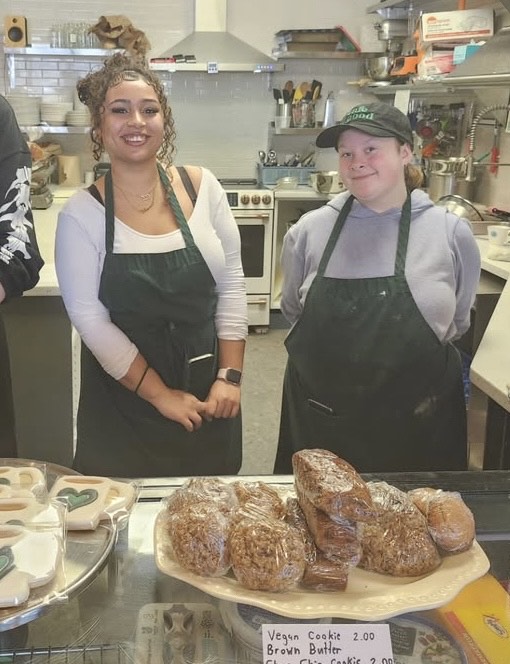 Olivia and Beth smiling proudly over a tray of fresh baked goodies